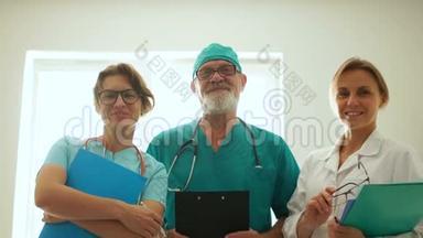 三名微笑医护人员.. 男医生和两名穿着医疗服的护士。 医药和保健概念